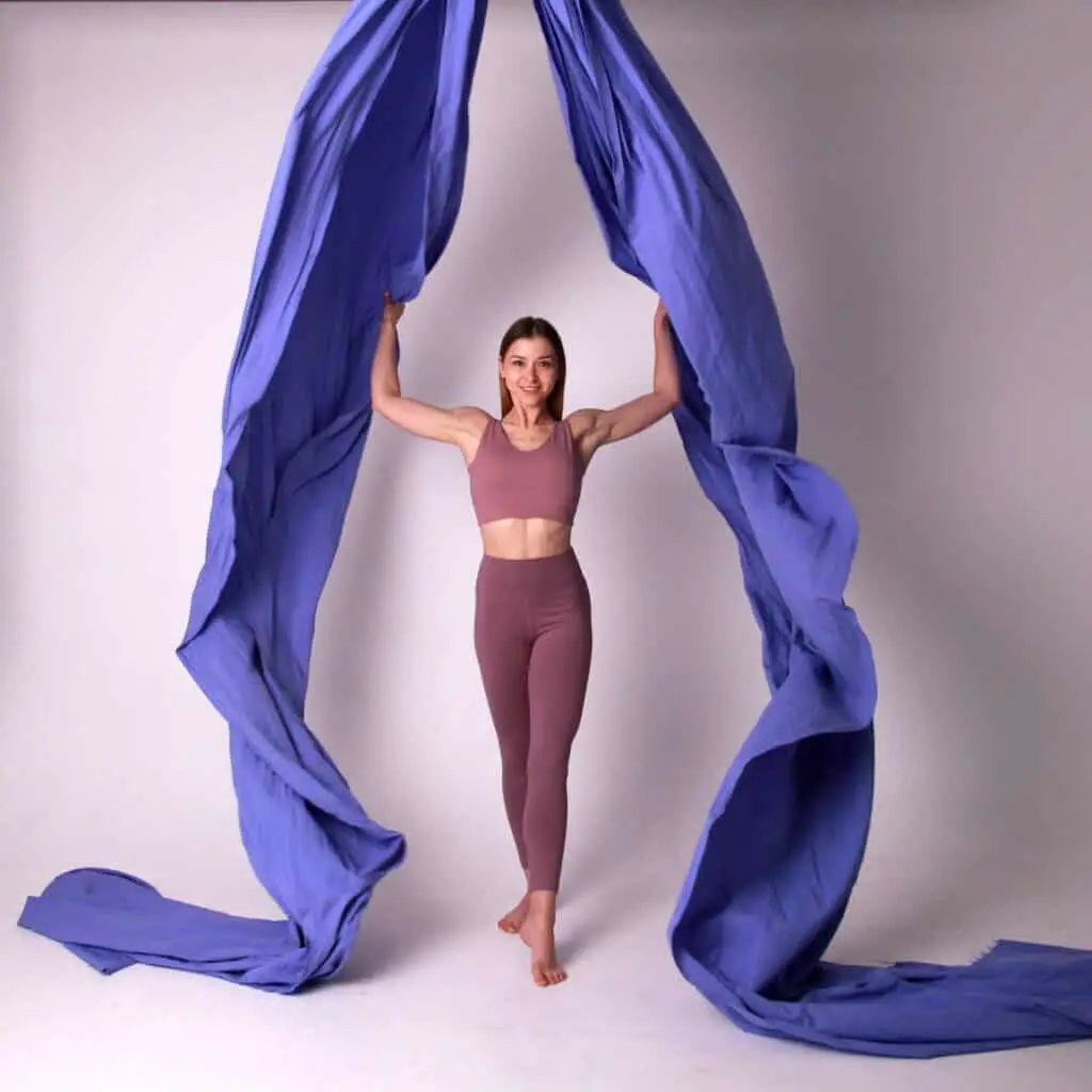 A women is playing yoga with fabric for muscle building